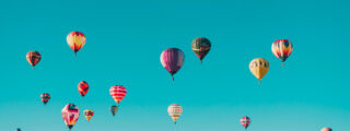 Un cielo azzurro con mongolfiere multicolore