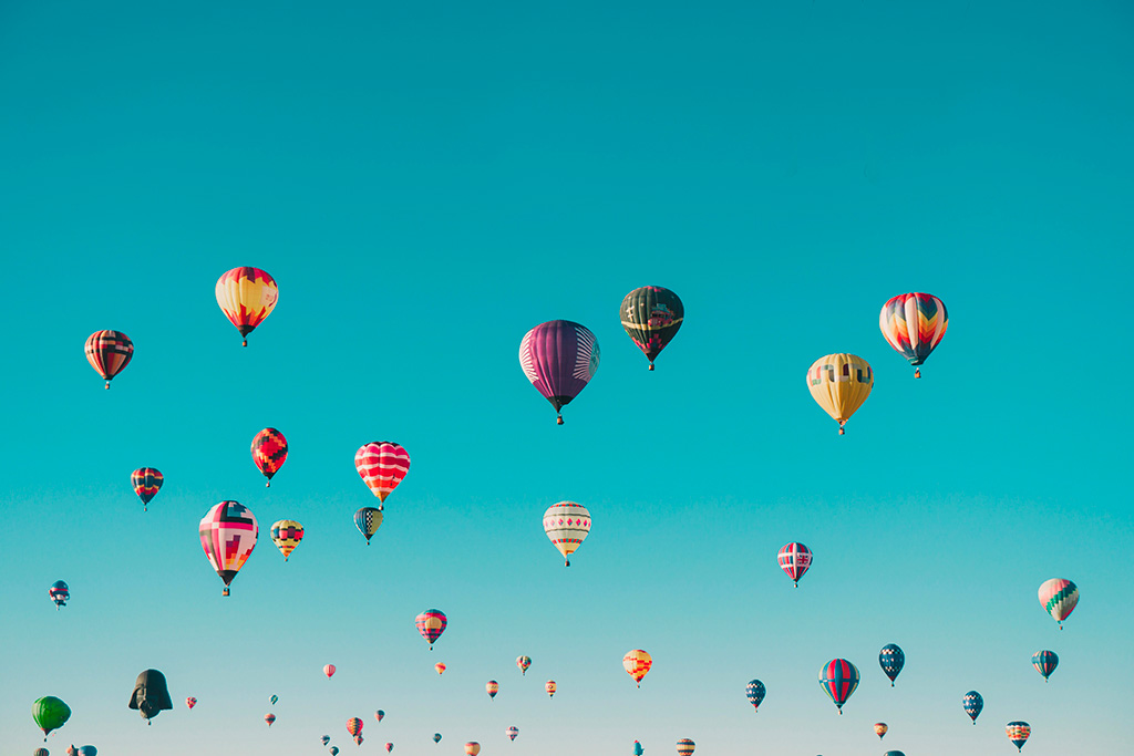Un cielo azzurro con mongolfiere multicolore